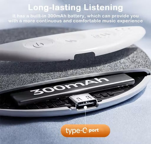 Close-up of a Under Pillow Bluetooth Speaker on a bed with a built-in battery and a visible USB-C port, shown with marketing text about 300mAh battery life and a type-C port callout.
